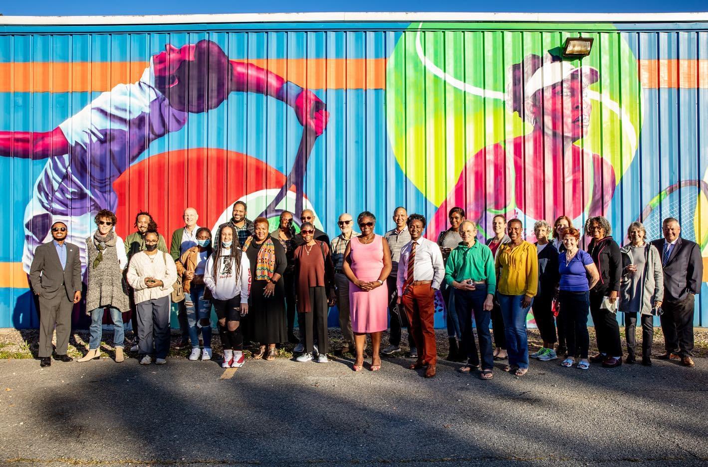 The staff of Sportsmen’s Tennis and Enrichment Center gather to unveil the center’s new mural, created by Artists for Humanity. (Photo by STEC) 