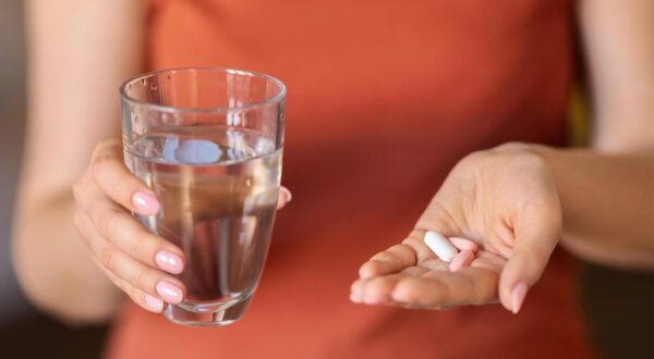 Unrecognizable Woman Holding Glass Of Water And Pile Of Pills In Hand, Closeup Shot Of Female Taking Vitamin Supplements For Beauty And Immunity Or Getting Medical Treatment, Cropped Image